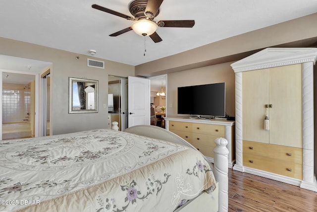 bedroom with hardwood / wood-style flooring, ensuite bathroom, and ceiling fan