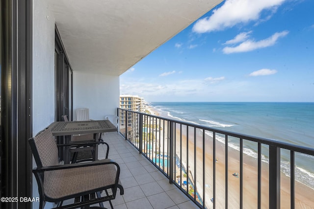 balcony featuring a water view and a view of the beach