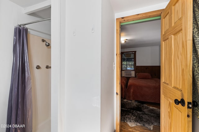 bathroom with a shower with curtain, cooling unit, and hardwood / wood-style flooring