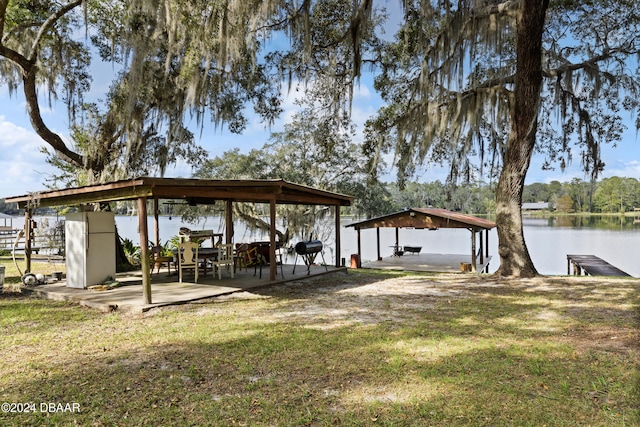 dock area featuring a water view and a lawn