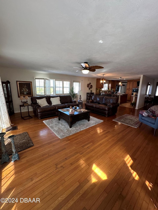 unfurnished living room with ceiling fan, wood-type flooring, and a textured ceiling