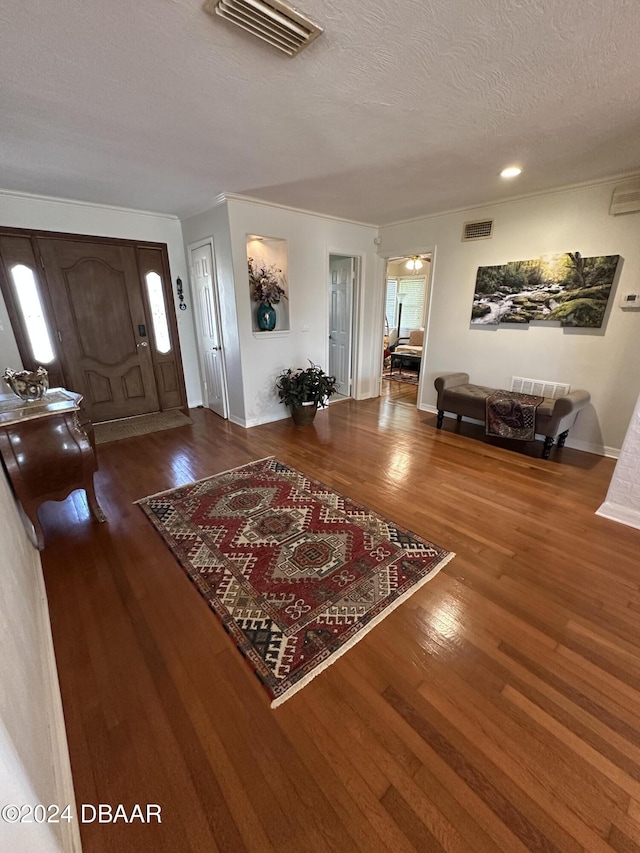 foyer with a textured ceiling and dark hardwood / wood-style floors