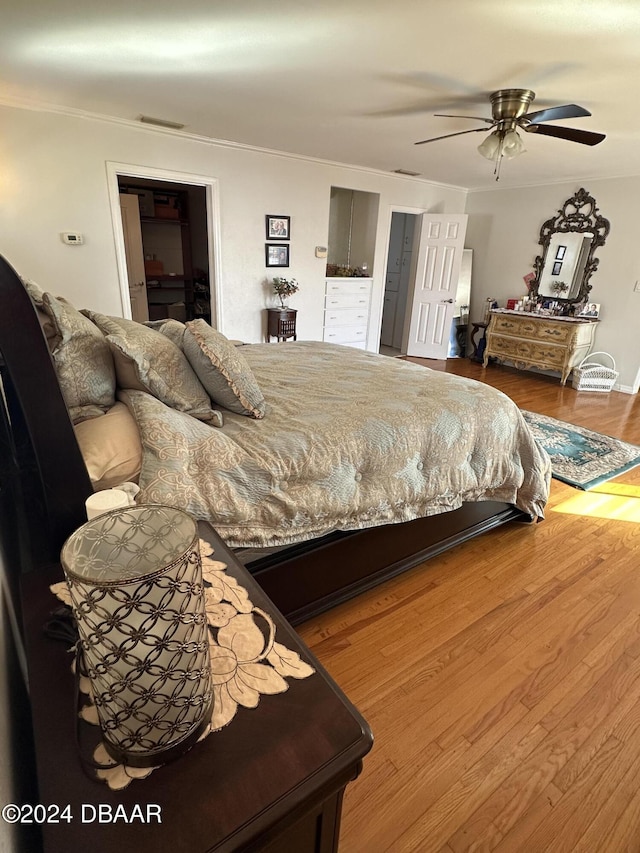 bedroom featuring hardwood / wood-style flooring, ceiling fan, and ornamental molding