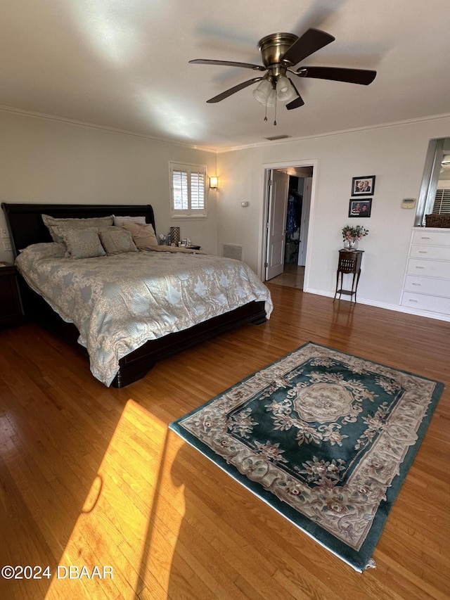 bedroom with hardwood / wood-style flooring, ceiling fan, and ornamental molding