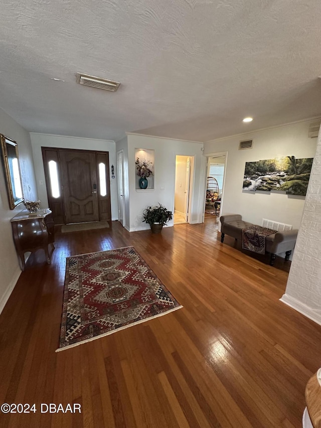 foyer with dark wood-type flooring and a textured ceiling