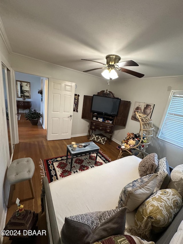 living room featuring dark hardwood / wood-style floors, ceiling fan, and ornamental molding