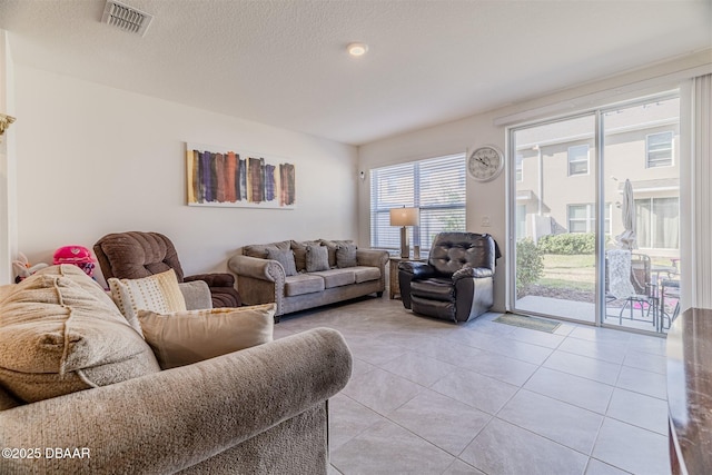 tiled living room featuring a textured ceiling