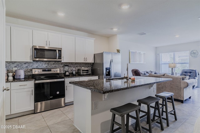 kitchen featuring white cabinetry, appliances with stainless steel finishes, sink, and a center island with sink