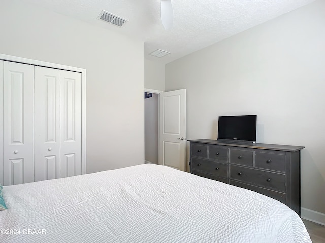 bedroom featuring a textured ceiling, ceiling fan, and a closet