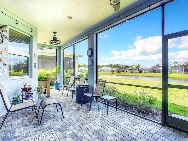 sunroom featuring a water view