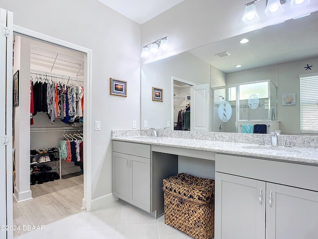 bathroom featuring walk in shower, vanity, and hardwood / wood-style floors