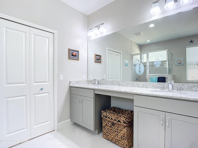 bathroom with vanity, tile patterned floors, and a shower with door