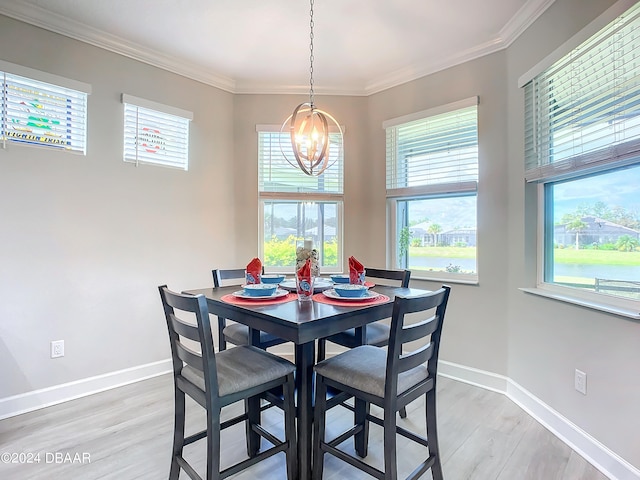 dining room with hardwood / wood-style flooring, an inviting chandelier, and crown molding