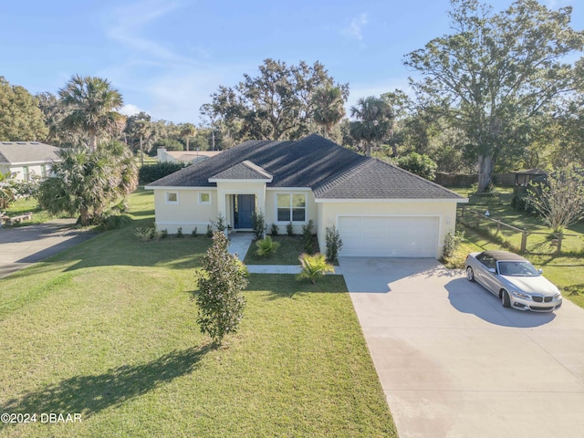 single story home with stucco siding, a shingled roof, concrete driveway, an attached garage, and a front yard