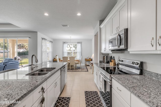 kitchen with white cabinets, appliances with stainless steel finishes, a wealth of natural light, and sink