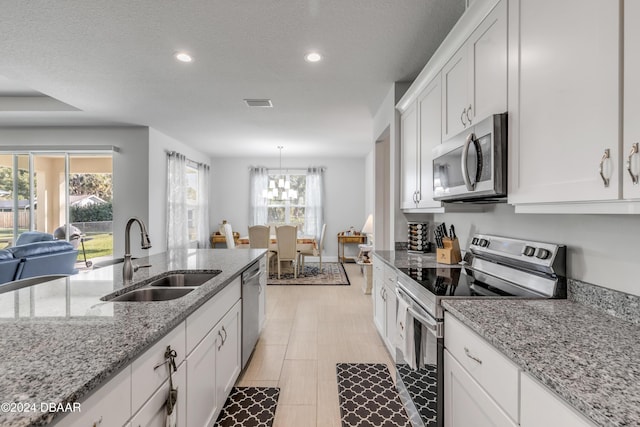 kitchen featuring recessed lighting, stainless steel appliances, a sink, visible vents, and white cabinetry