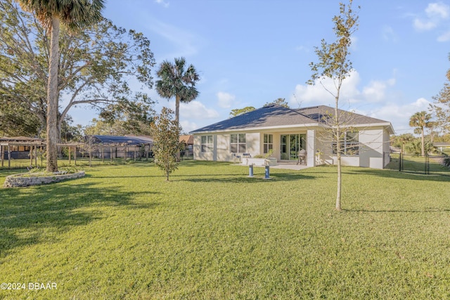 rear view of house with a lawn, a patio area, and fence