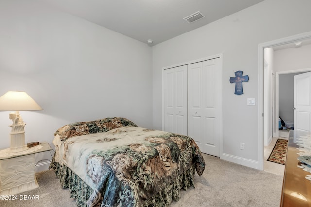 bedroom featuring light colored carpet and a closet