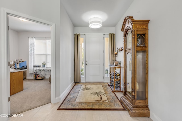 carpeted entrance foyer featuring baseboards