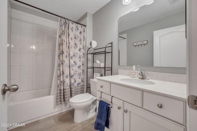 full bathroom featuring a textured ceiling, hardwood / wood-style floors, shower / bath combo with shower curtain, vanity, and toilet