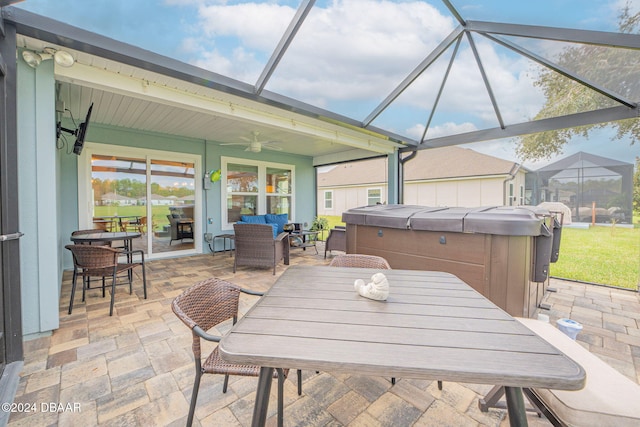 view of patio featuring a lanai, ceiling fan, and a hot tub