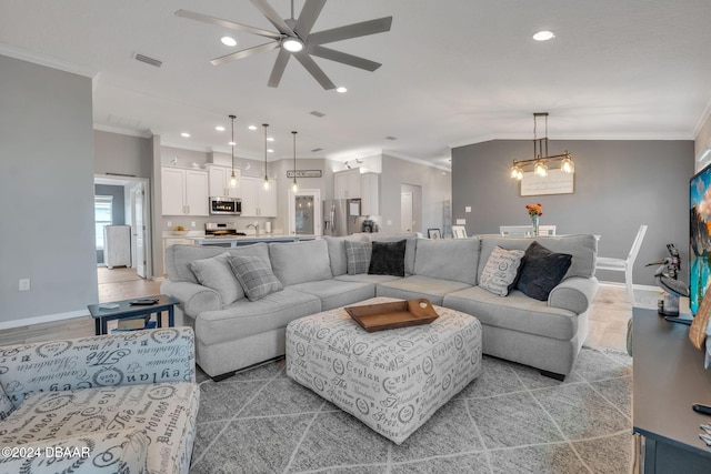 living room with ceiling fan with notable chandelier, vaulted ceiling, and ornamental molding