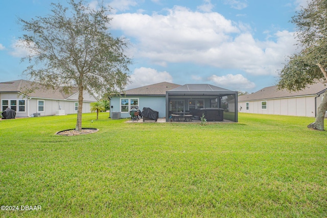 rear view of house with a lanai, a patio, and a yard