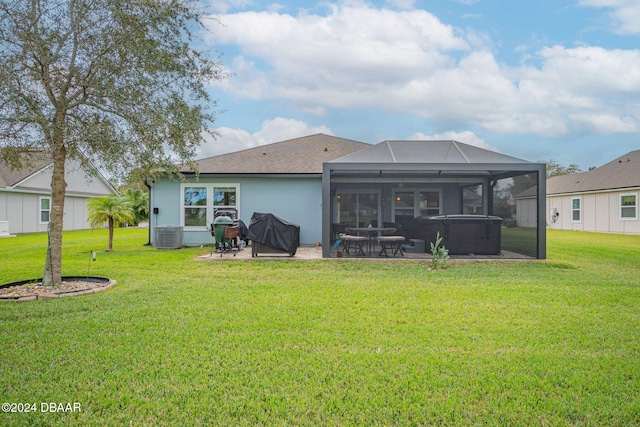 rear view of property featuring a patio, a lawn, and a lanai