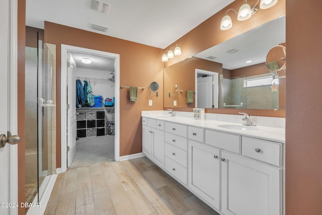 bathroom with walk in shower, hardwood / wood-style floors, and vanity