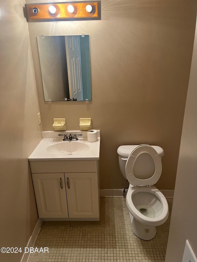 bathroom featuring toilet, vanity, and tile patterned flooring