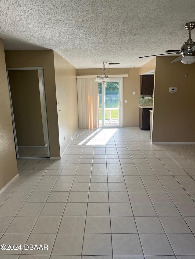 tiled spare room with ceiling fan and a textured ceiling