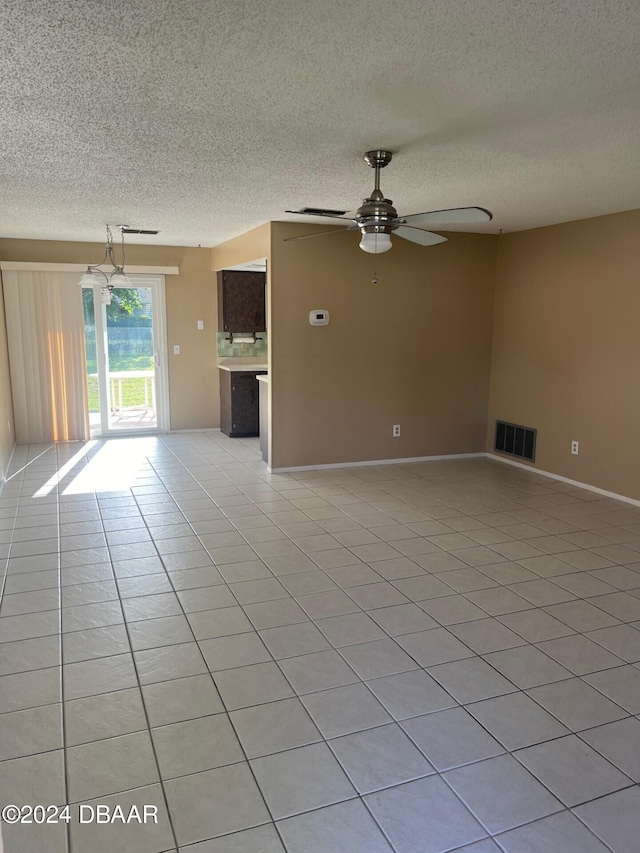 tiled empty room with a textured ceiling and ceiling fan