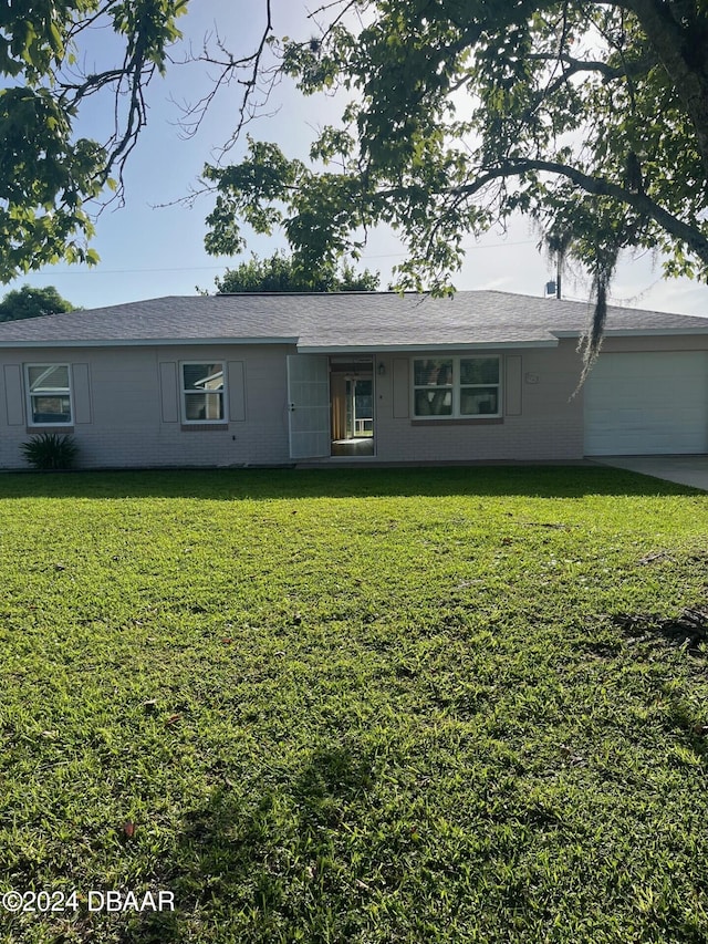 single story home with a garage and a front lawn