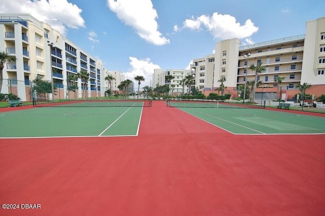 view of tennis court featuring community basketball court and fence