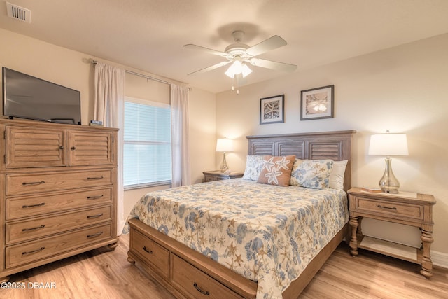 bedroom with baseboards, visible vents, light wood finished floors, and ceiling fan