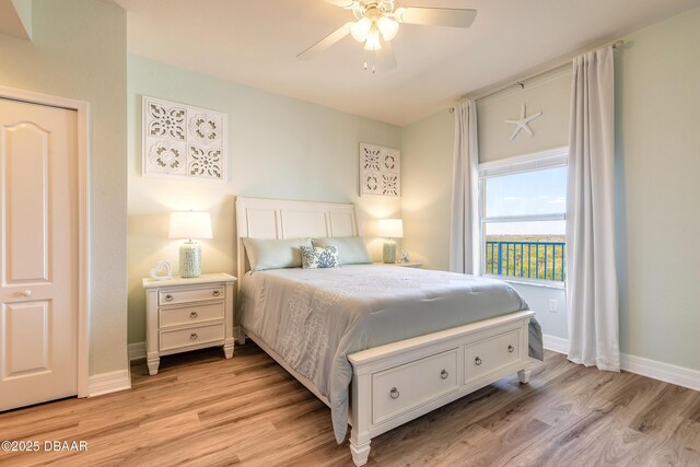 bedroom featuring light wood-style flooring, a ceiling fan, and baseboards