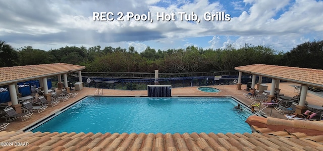 pool with a patio area, cooling unit, and a hot tub