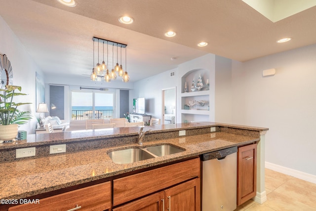 kitchen featuring light stone countertops, open floor plan, dishwasher, brown cabinets, and a sink