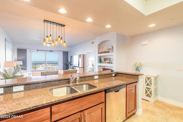 kitchen with pendant lighting, light stone counters, stainless steel dishwasher, and sink