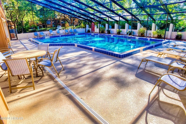 view of swimming pool with a patio and a lanai