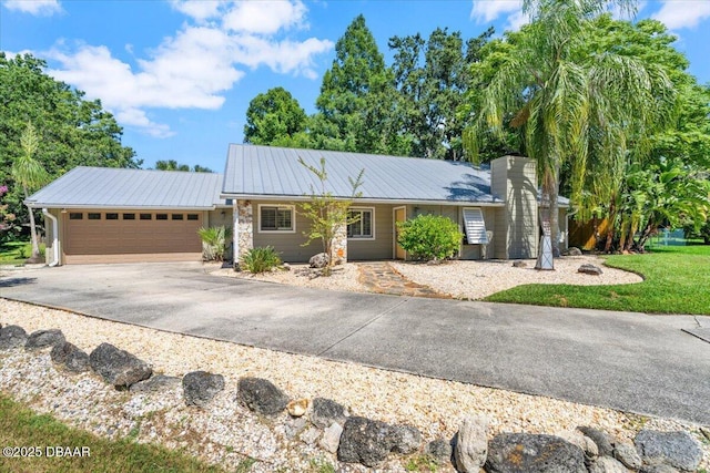 232 Chippewa Cir, Ormond Beach, FL 32174 - ranch-style house with a garage, asphalt driveway, a metal roof, and stone siding
