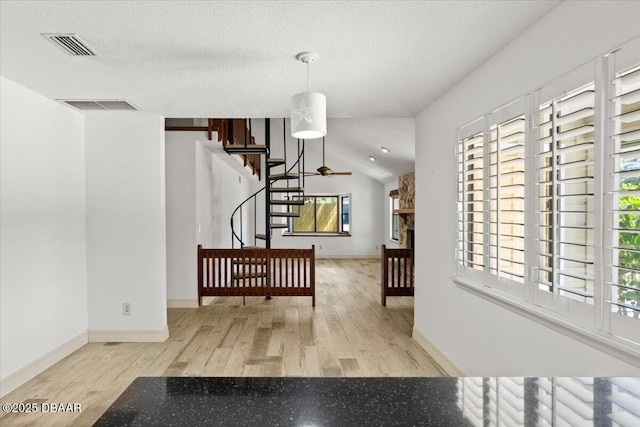232 Chippewa Cir, Ormond Beach, FL 32174 - hallway with wood finished floors, stairs, a textured ceiling, and vaulted ceiling