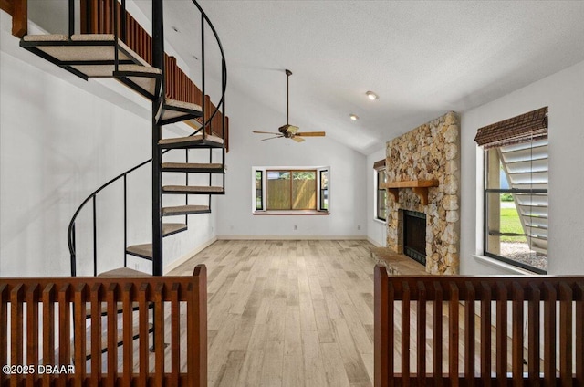 232 Chippewa Cir, Ormond Beach, FL 32174 - unfurnished living room featuring wood finished floors, stairway, ceiling fan, a stone fireplace, and lofted ceiling