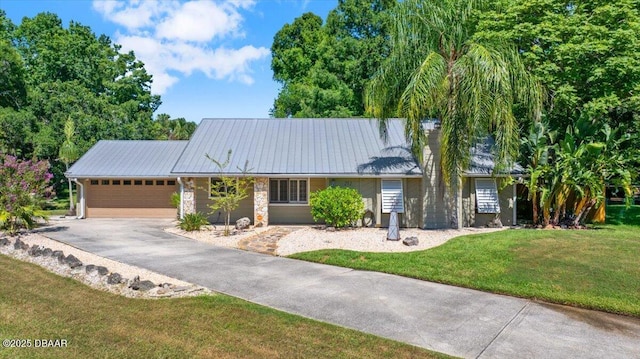 232 Chippewa Cir, Ormond Beach, FL 32174 - ranch-style home with a garage, asphalt driveway, a front yard, a metal roof, and stone siding