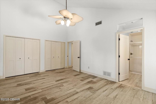 232 Chippewa Cir, Ormond Beach, FL 32174 - unfurnished bedroom with high vaulted ceiling, wood finished floors, two closets, and connected bathroom