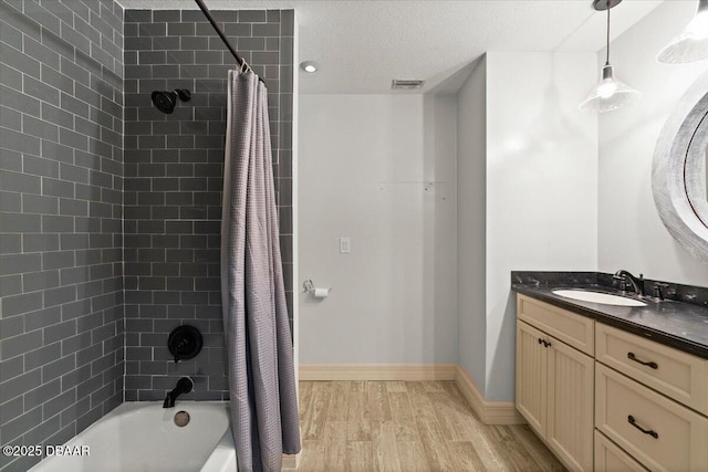 232 Chippewa Cir, Ormond Beach, FL 32174 - full bathroom featuring wood finished floors, shower / tub combo with curtain, vanity, and a textured ceiling