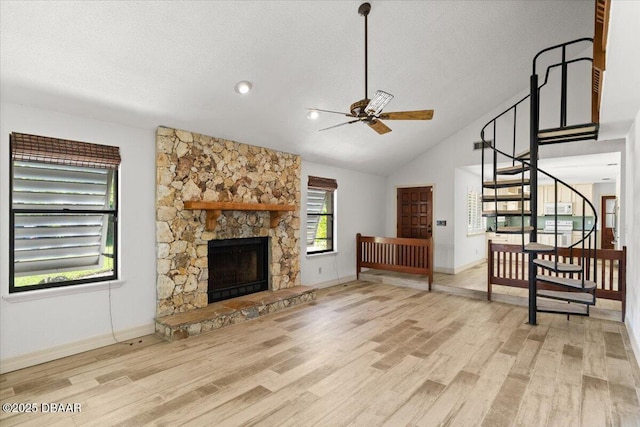 232 Chippewa Cir, Ormond Beach, FL 32174 - unfurnished living room with ceiling fan, stairway, wood finished floors, a stone fireplace, and lofted ceiling