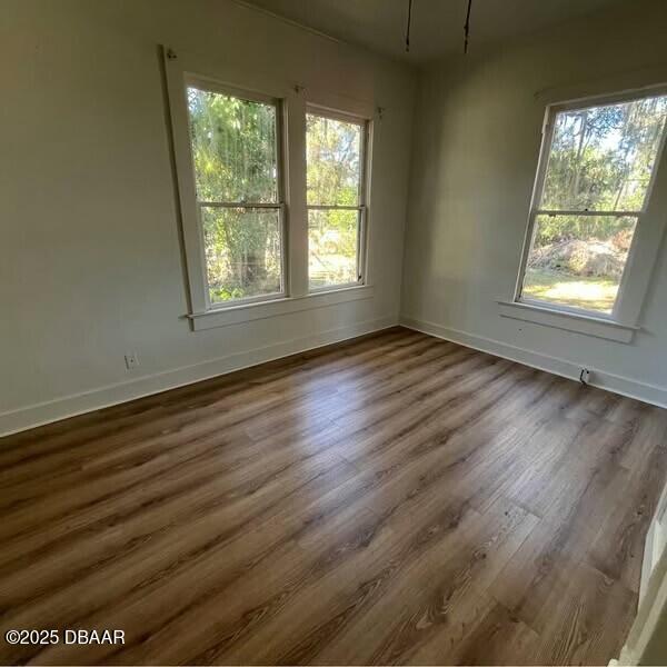 unfurnished room with dark hardwood / wood-style flooring