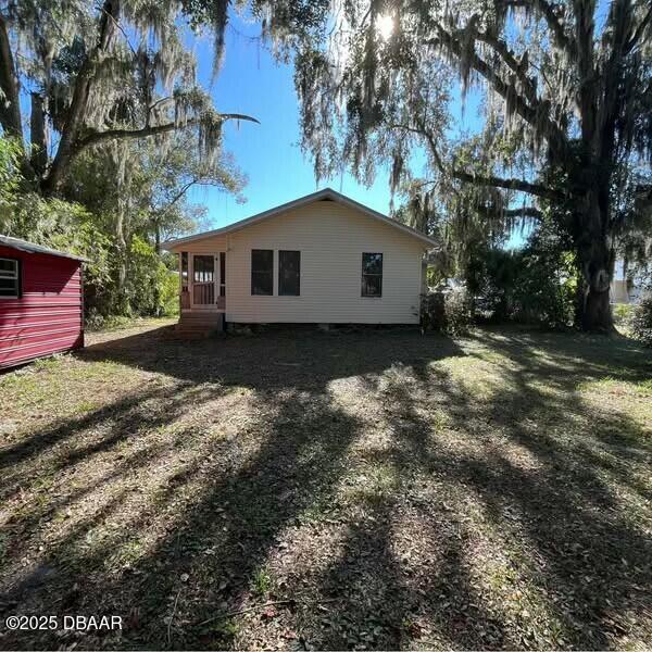 view of side of property featuring a yard and a shed