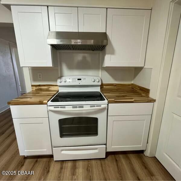 kitchen featuring white cabinets, extractor fan, and white electric stove